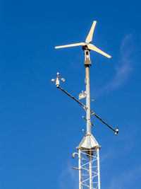 Low angle view of communications tower against blue sky