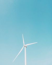 Low angle view of wind turbine against clear blue sky