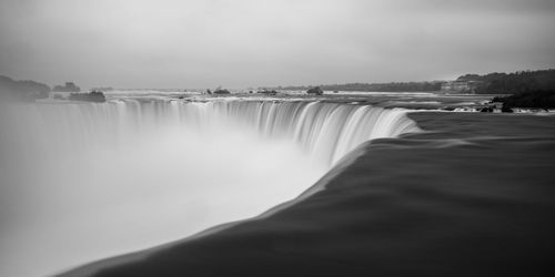 Scenic view of waterfall against sky