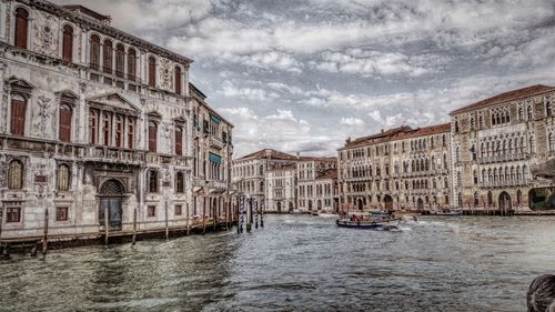 Buildings in city against cloudy sky