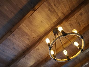 Low angle view of illuminated pendant light hanging from ceiling