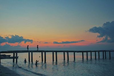 Pier on sea at sunset