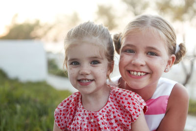 Portrait of cute smiling sisters outdoors