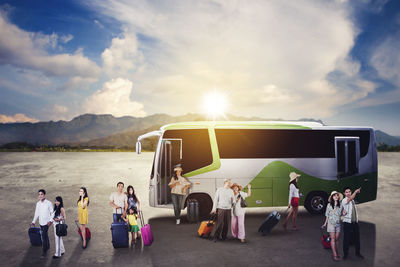 People on road against cloudy sky