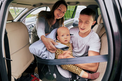 Portrait of young woman sitting in car