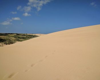 Sand dunes in desert against clear blue sky