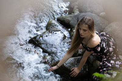 High angle view of woman sitting on rock