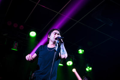 Man singing on illuminated stage at night