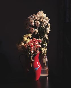 Close-up of flower vase on table against black background