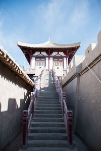 Low angle view of steps amidst buildings against sky