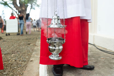 Lower part of catholic church members with incense in the campo santo cemetery 