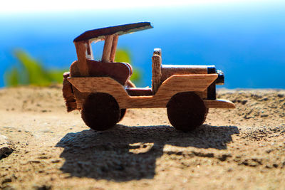 Close-up of toy car on sand at beach against sky