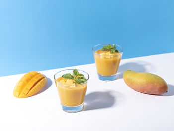 Glass of drink on table against blue background