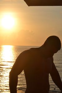 Sun shining through clouds over sea