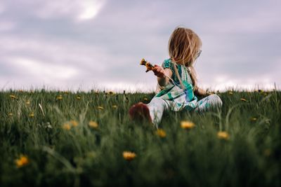 Girl picking flowers on field