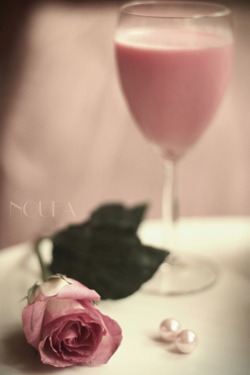 indoors, freshness, flower, pink color, close-up, table, still life, food and drink, glass - material, wineglass, fragility, transparent, drinking glass, refreshment, petal, selective focus, drink, no people, focus on foreground, vase