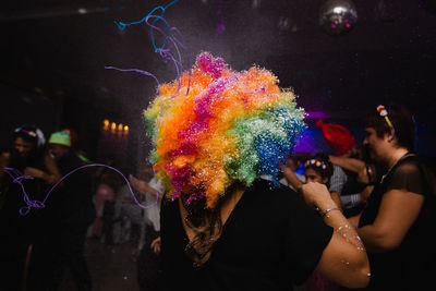 Rear view of woman wearing colorful wig in party