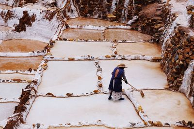 Rear view of man standing on snow covered mountain