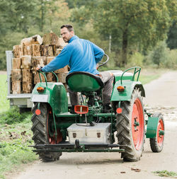 Full length of man driving tractor on road