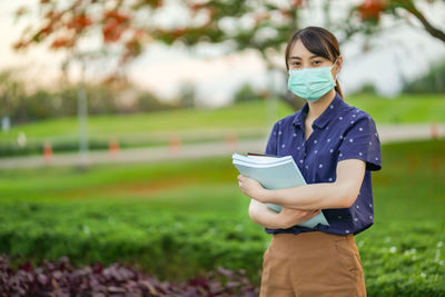 Portrait of a young woman standing on field