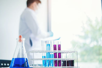 Scientist working with laboratory glassware in foreground