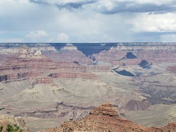Rock formations on landscape against cloudy sky