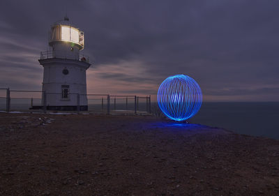 Illuminated tower against sky at night