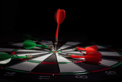 Close-up of illuminated lighting equipment on table against black background