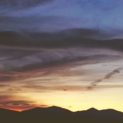Low angle view of silhouette mountain against dramatic sky