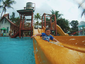 Boy playing on slide at playground