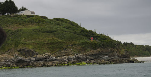 Scenic view of rocks by sea against sky