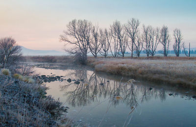 Scenic view of lake against sky during sunset