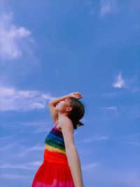 Side view of girl standing against sky