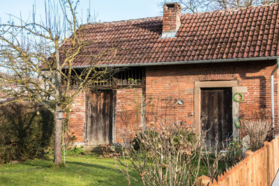 Exterior of old house on field against building