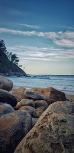 Rocks on beach against sky