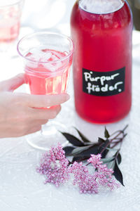 Close-up of hand holding lemonade in glass