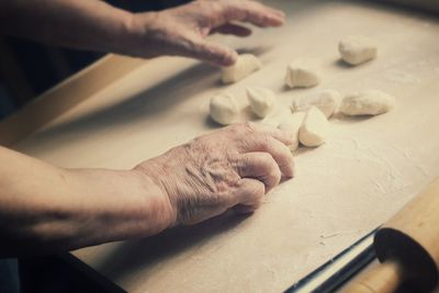 Close-up of hands kneading dough on table
