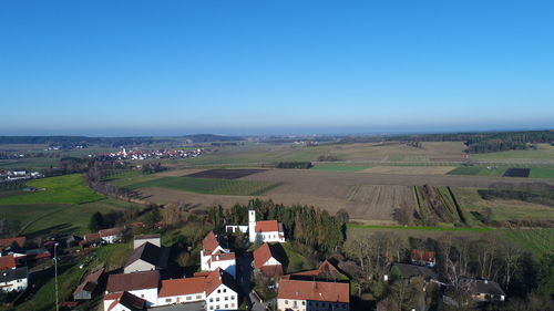 Aerial view of agricultural field against clear blue sky