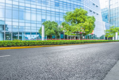 Empty road by buildings in city