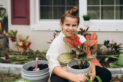 Portrait of cute girl holding potted plant