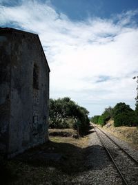 Railroad track amidst field against sky