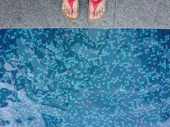 Low section of man swimming in pool