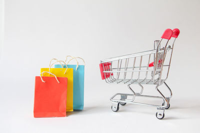 High angle view of miniature shopping cart against white background