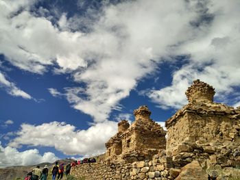 Low angle view of old ruin building against cloudy sky