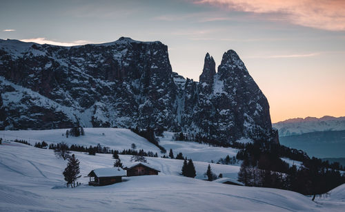 Scenic view of snow covered mountains against sky during sunset