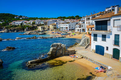 High angle view of buildings by sea against clear sky