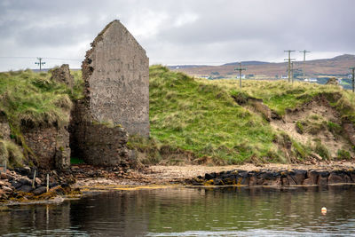 Built structure on riverbank against sky