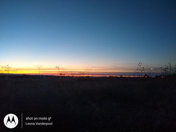 Scenic view of field against clear sky during sunset