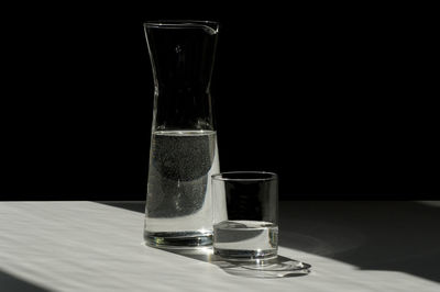 Close-up of water in glass on table against black background