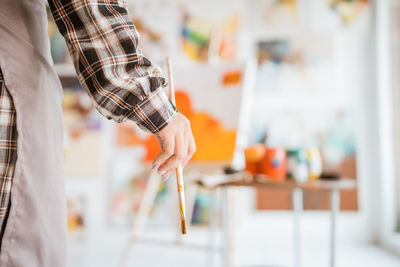 Midsection of woman holding paintbrush